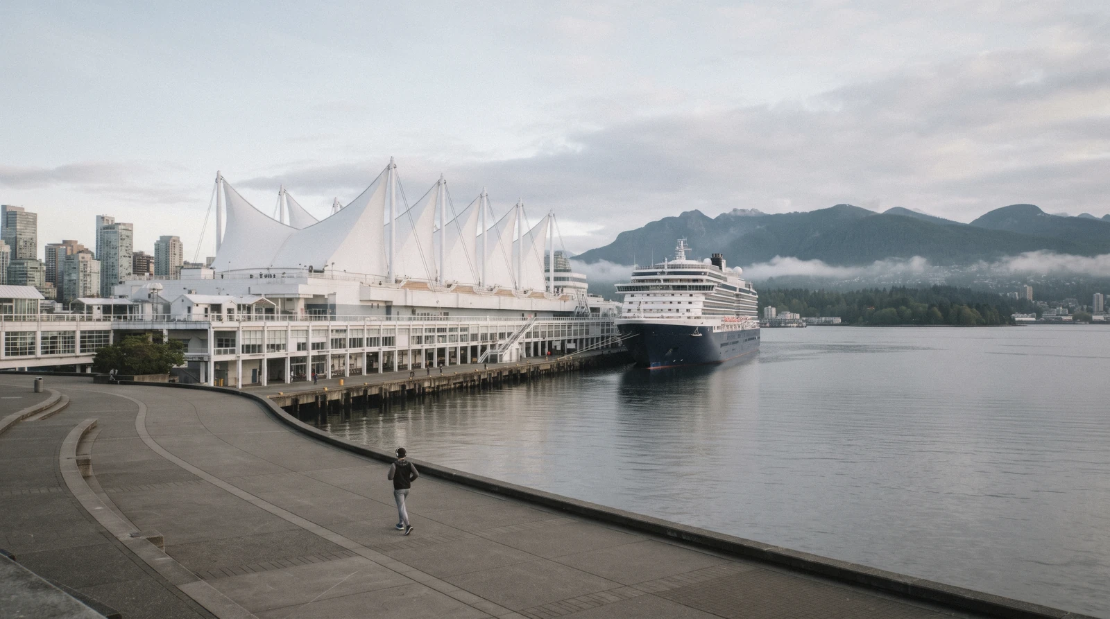 The five white sails of Canada Place above the cruise terminal and Burrard Inlet with the North Shore mountains behind, Vancouver