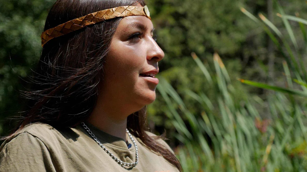 Indigenous guide explaining native plants beside Beaver Lake, Stanley Park Talking Trees tour Vancouver