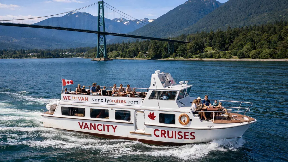 Small sightseeing boat cruising False Creek with the downtown skyline behind, Vancouver city sightseeing boat tour with live guide