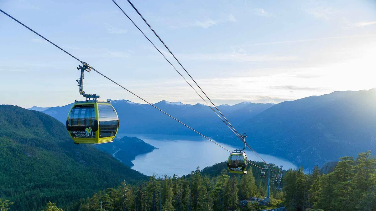 Gondola cabin rising above Howe Sound toward the summit suspension bridge, Sea to Sky Gondola admission ticket Squamish