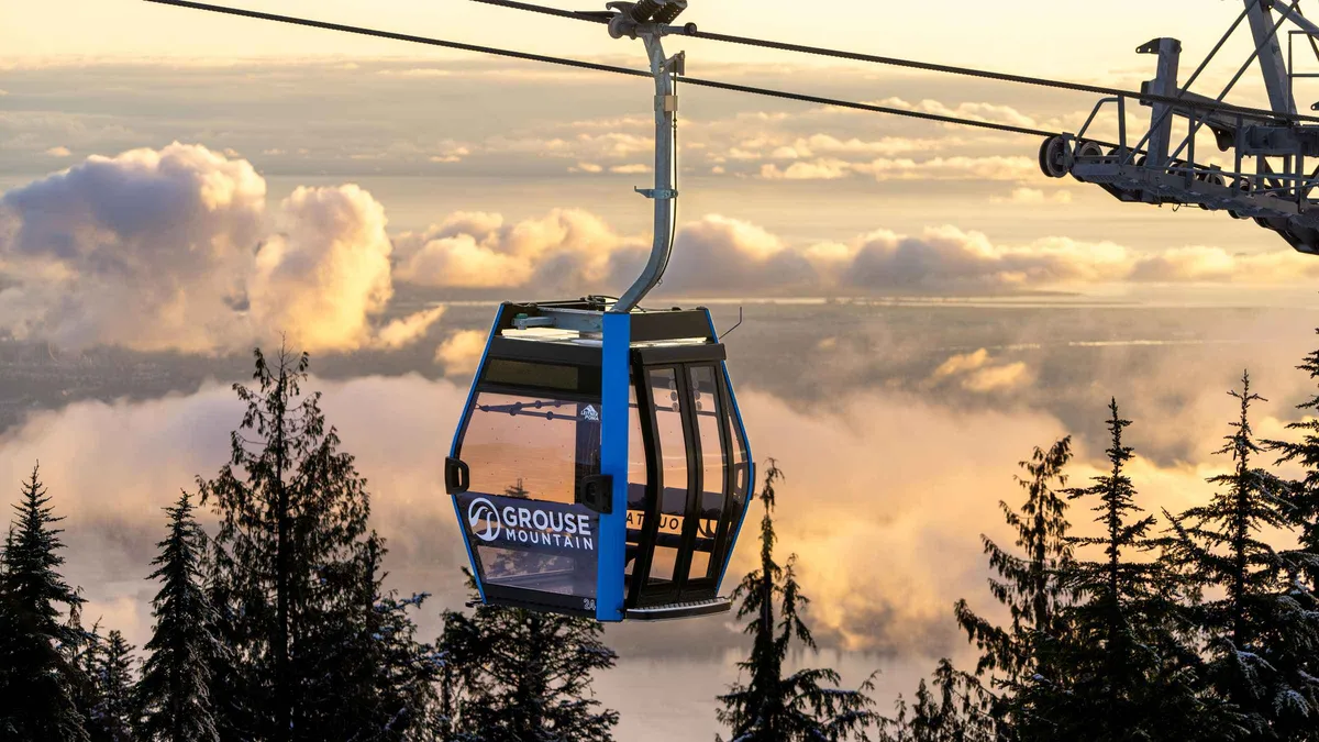 Skyride gondola climbing Grouse Mountain above the North Shore forest on a Grouse Mountain and Capilano Bridge tour from Vancouver
