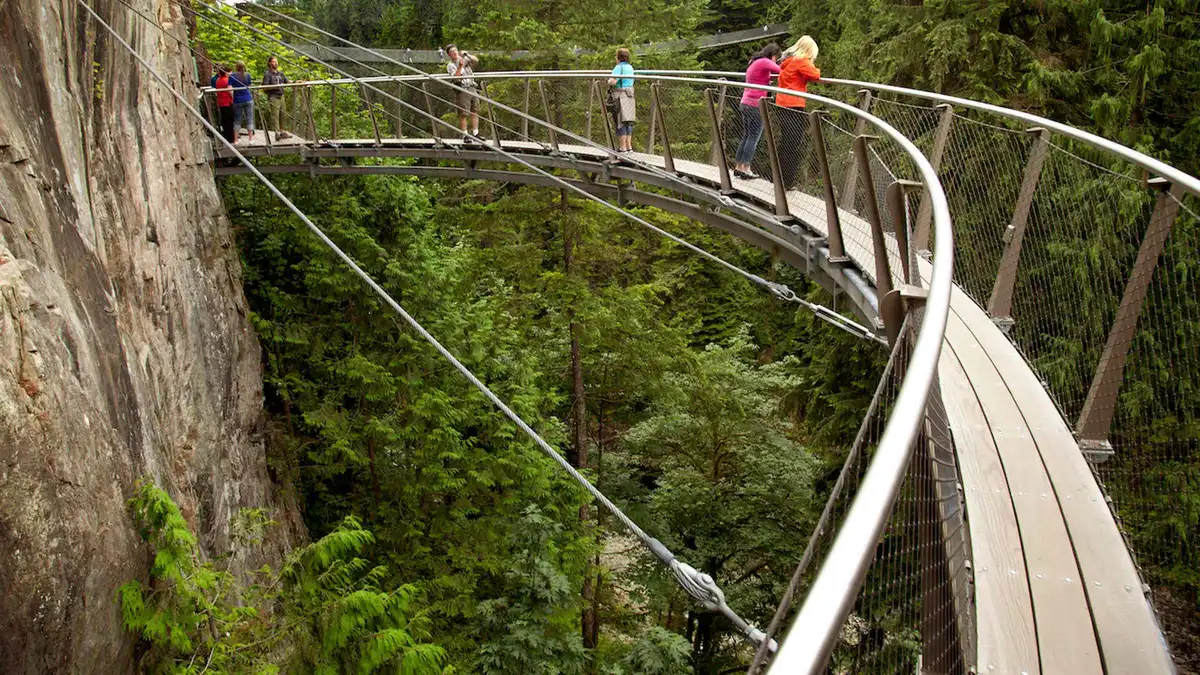 Small group crossing the Capilano Suspension Bridge before riding the Grouse Mountain Skyride, Capilano and Grouse Mountain tour with tickets included Vancouver